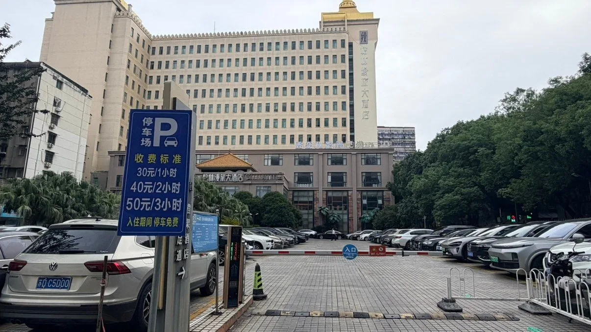 格林缦旅大酒店停车场入口收费标准公示牌：30元/1小时、40元/2小时、50元/3小时、入住期间停车免费